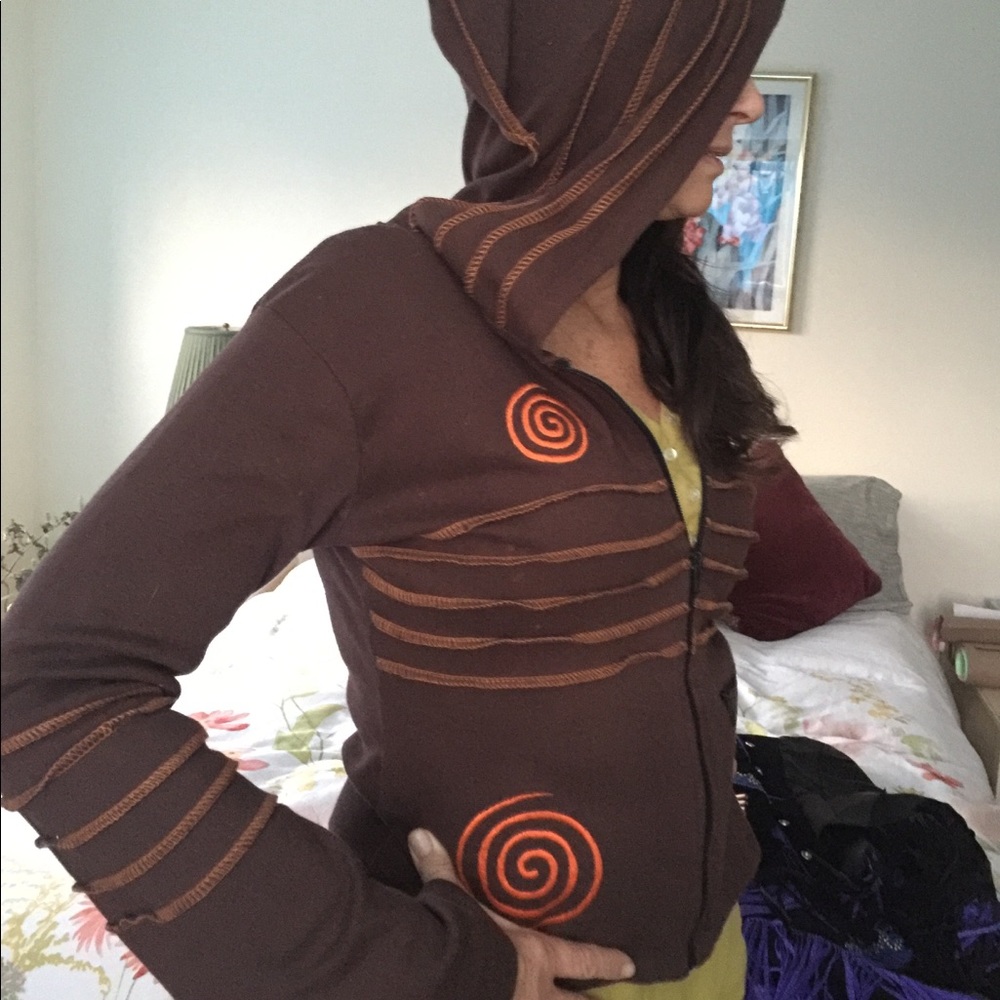 Long pointed hoodie with spiral embroidery trim.